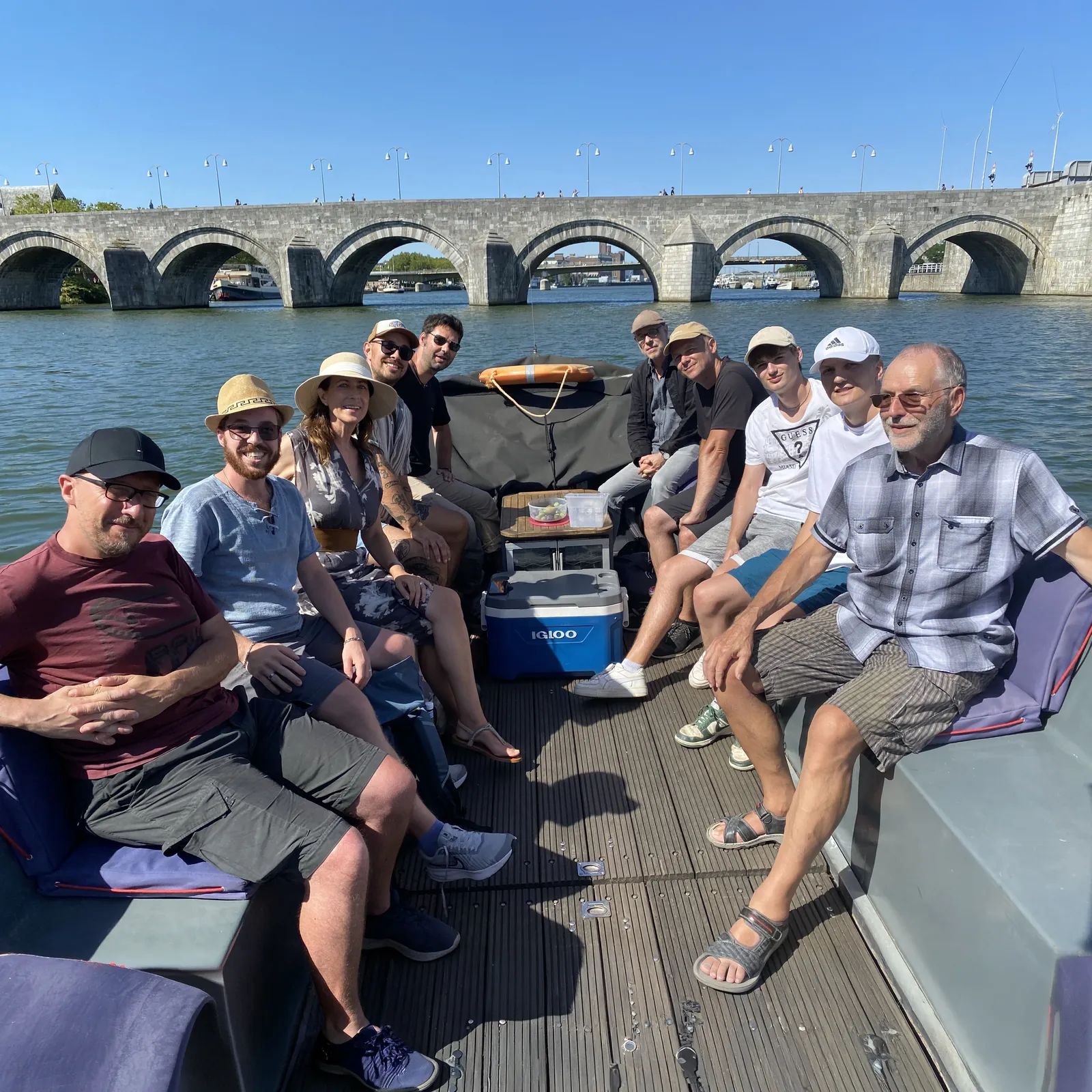 Das Coroga-Team bei einer gemeinsamen Bootstour vor einer alten Steinbogenbrücke